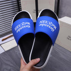 Alexander McQueen slide sandals, top view with blue logo straps and black footbeds