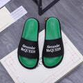 Green slide sandals with black strap and Alexander McQueen logo