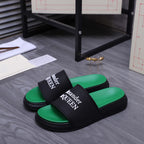 Green slide sandals with black wide strap showing Alexander McQueen logo