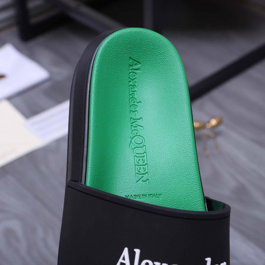 Green footbed of a slide sandal with embossed Alexander McQueen text