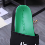 Green footbed of a slide sandal with embossed Alexander McQueen text