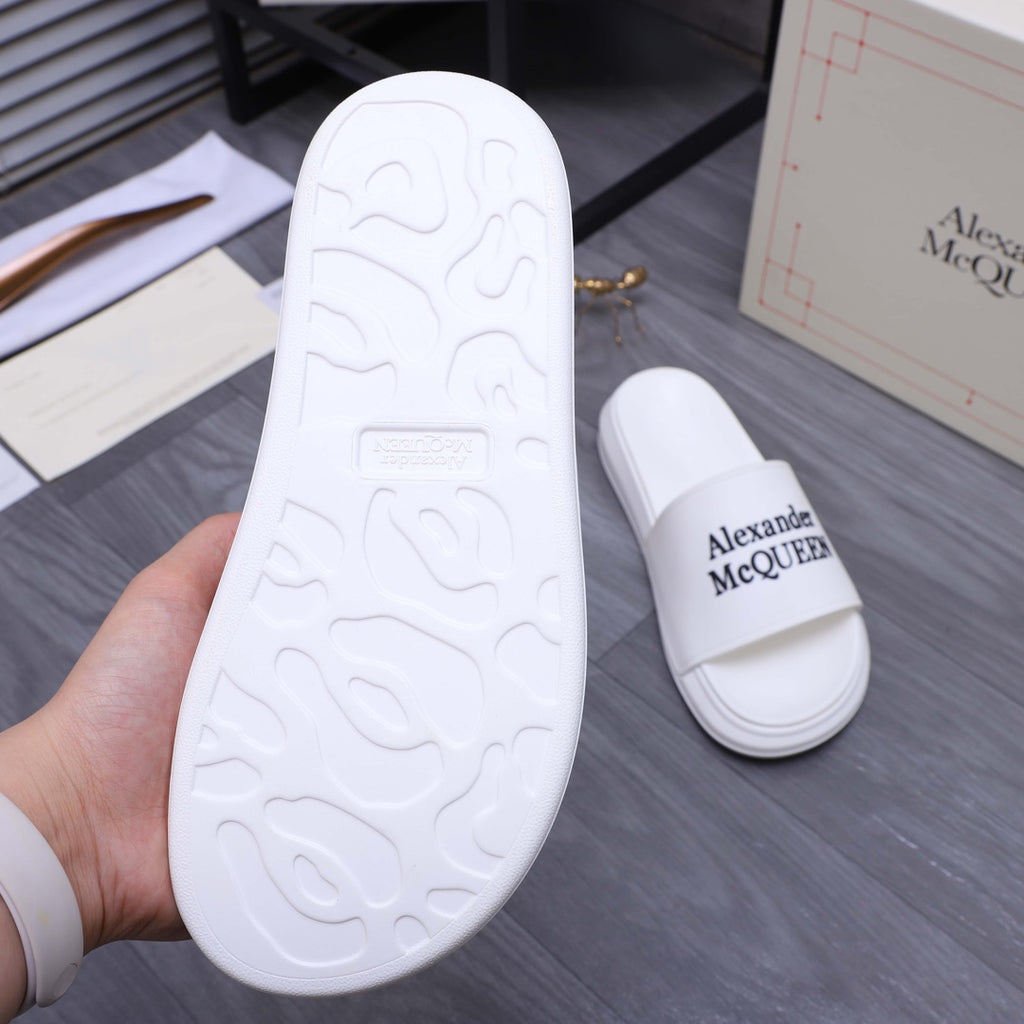 Alexander McQueen white slide sandal outsole with textured tread, sole and pair