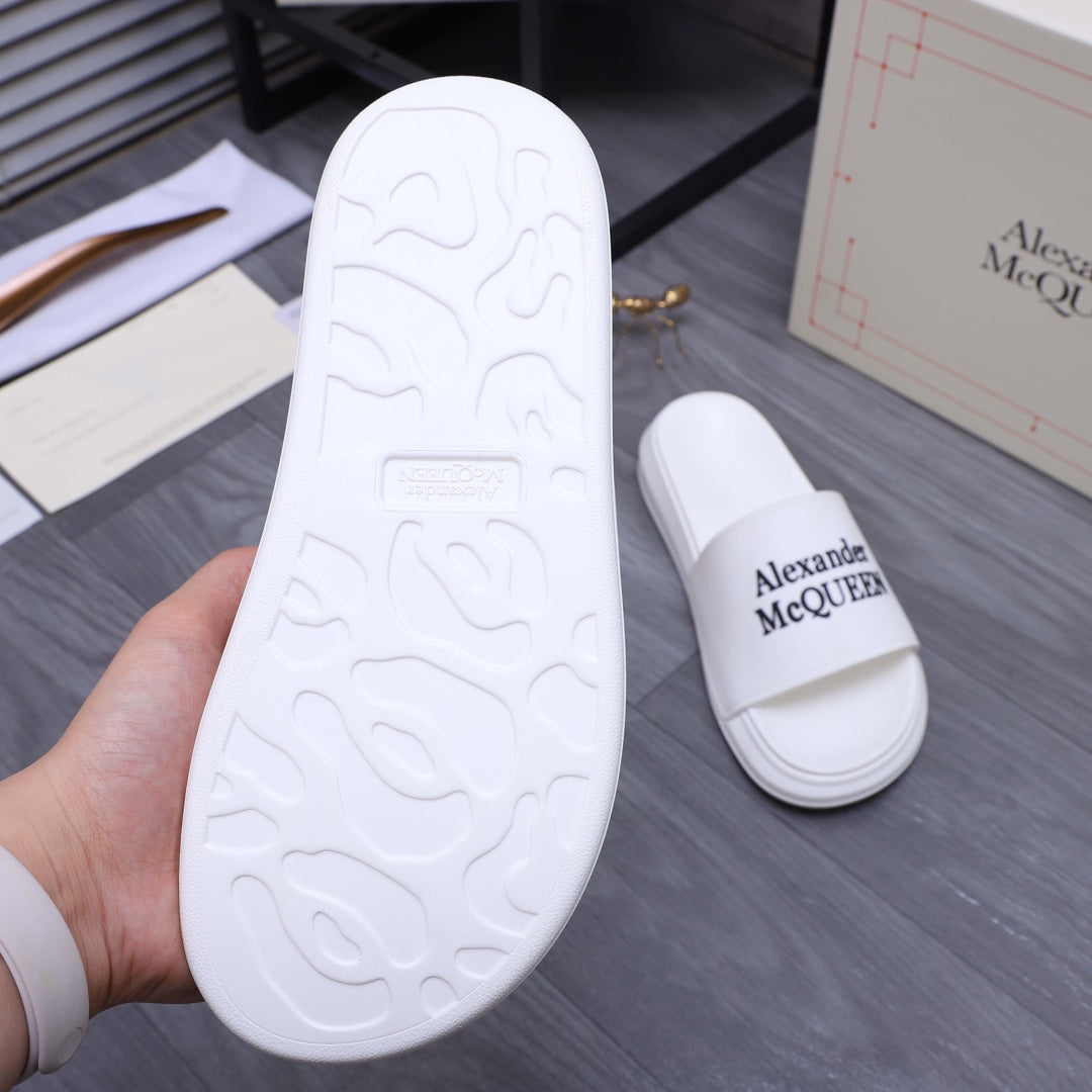 Alexander McQueen white slide sandal outsole with textured tread, sole and pair