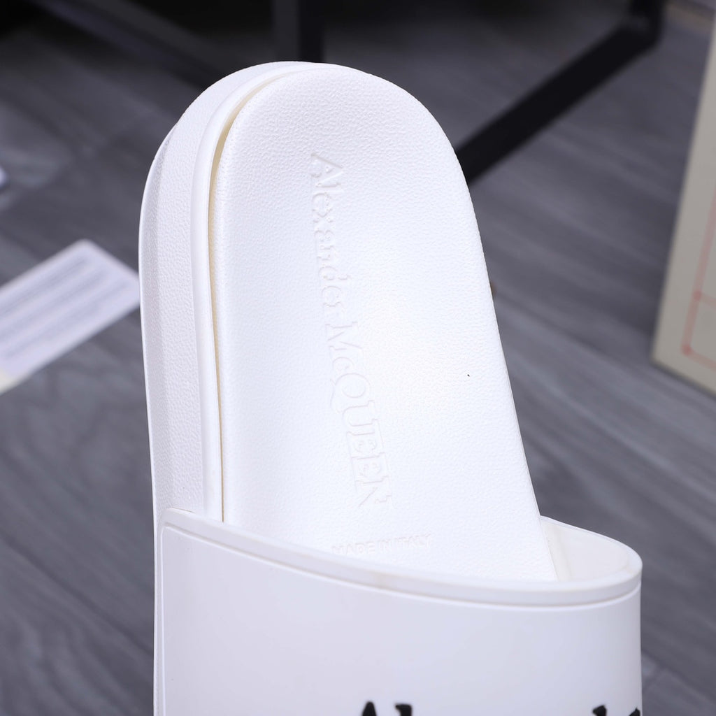 Alexander McQueen white slide sandal footbed with embossed logo, close-up