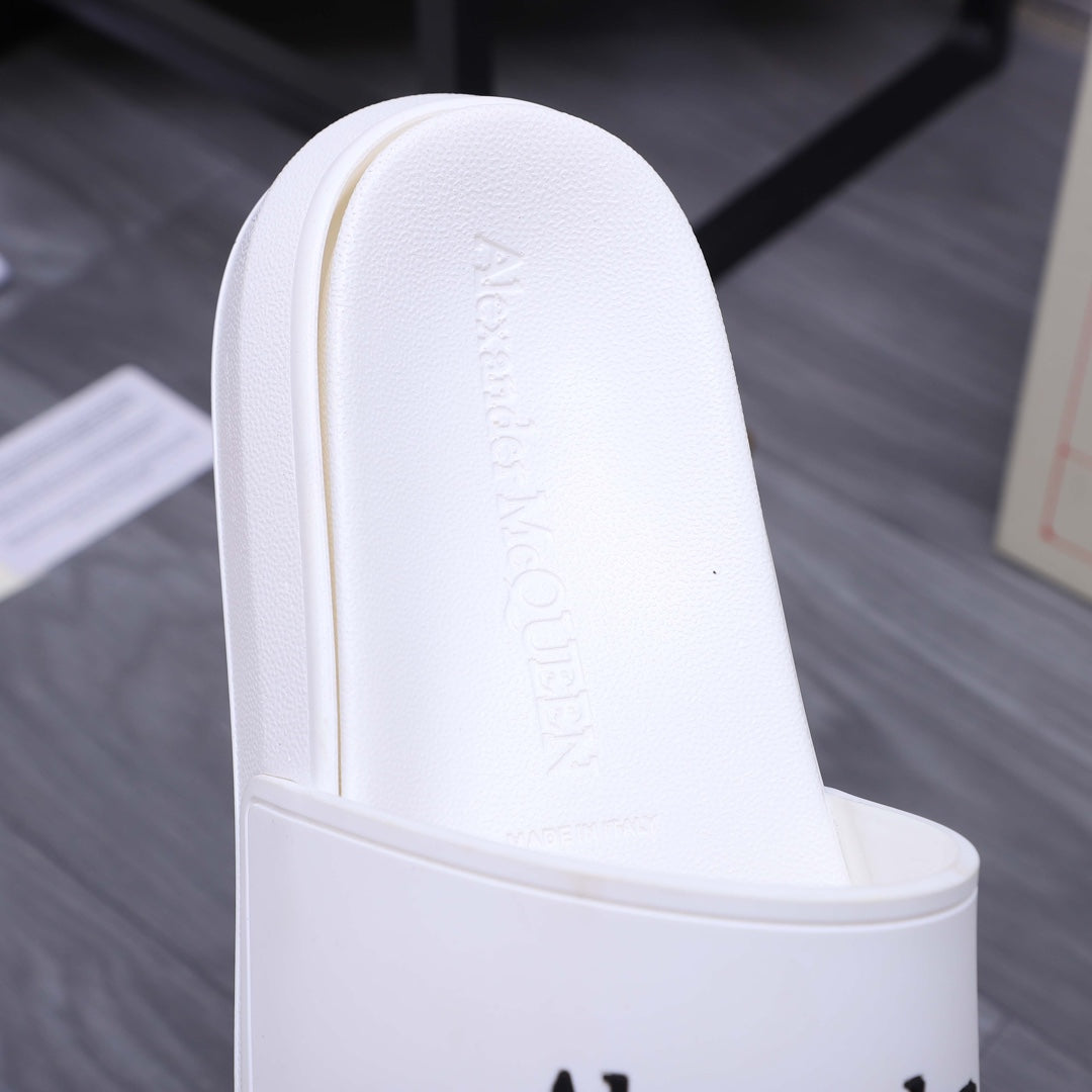 Alexander McQueen white slide sandal footbed with embossed logo, close-up