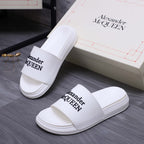 Alexander McQueen white leather slide sandals with logo straps, side view pair