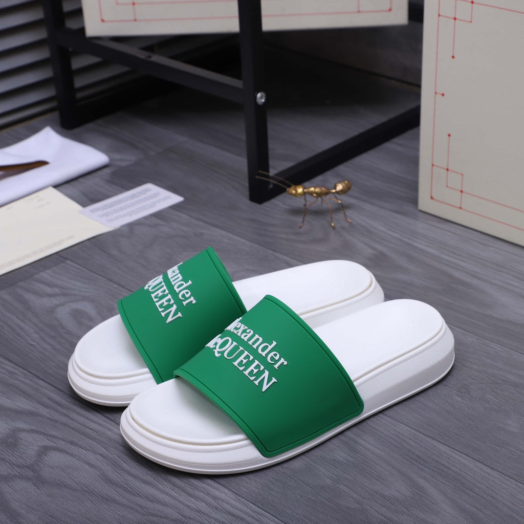 White slide sandals with green logo straps, side view