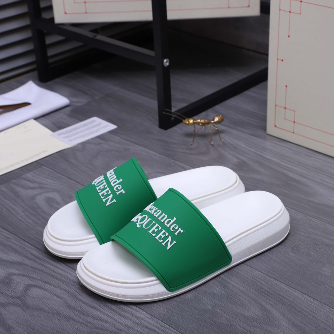 White slide sandals with green logo straps, side view