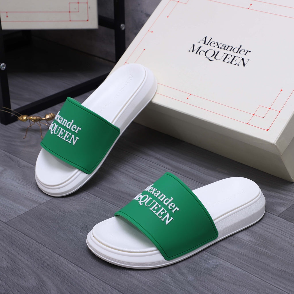 White slide sandals with green logo bands, angled view