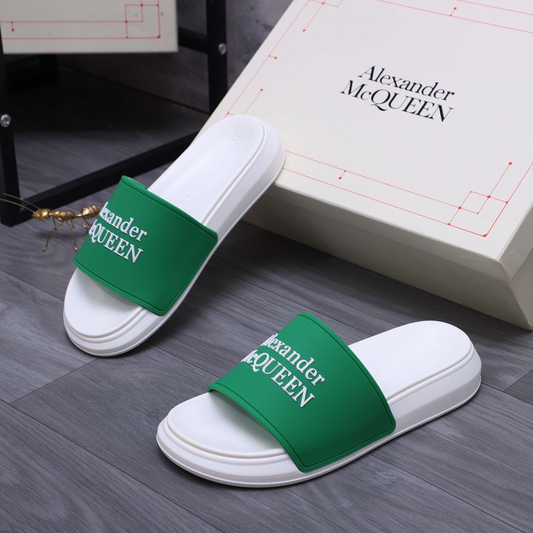 White slide sandals with green logo bands, angled view