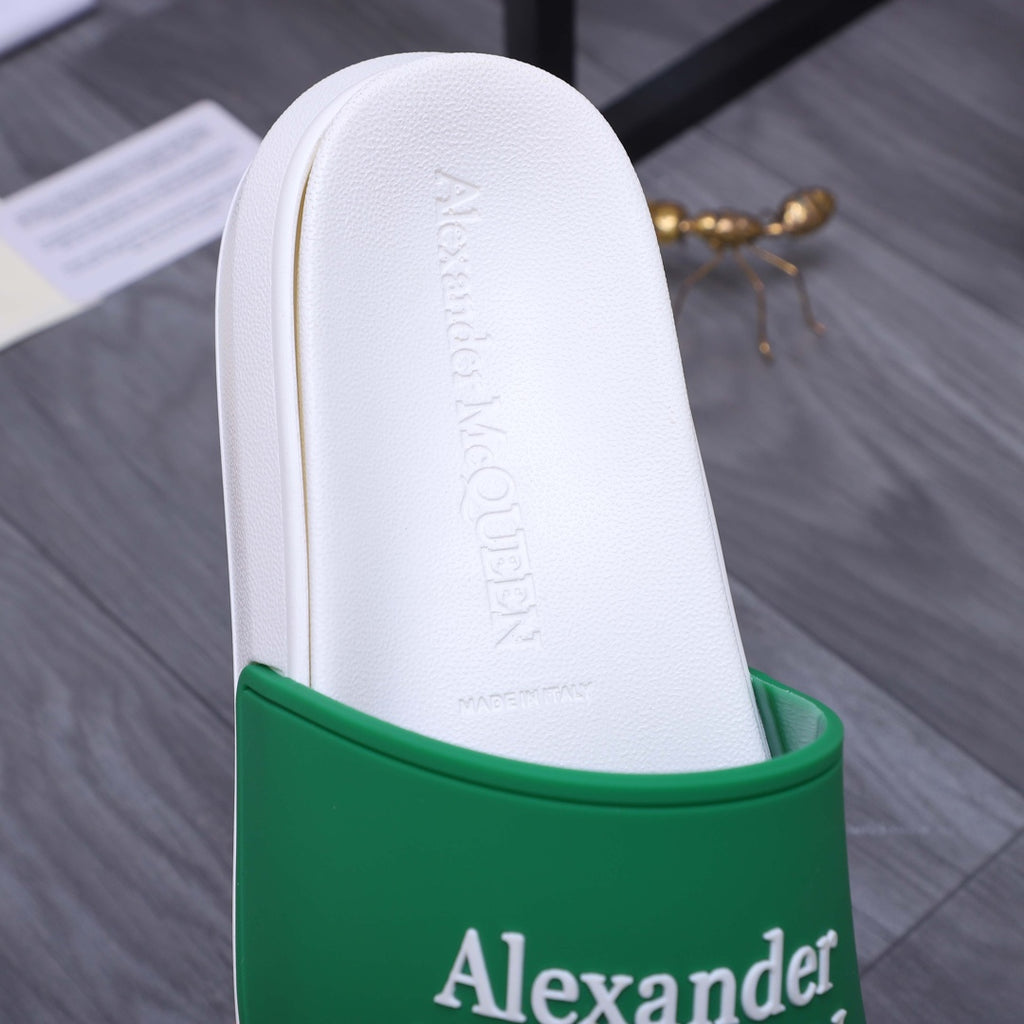 White slide sandal showing insole and green logo strap