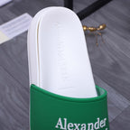 White slide sandal showing insole and green logo strap