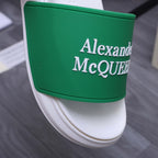 White slide sandal with green logo strap, close-up