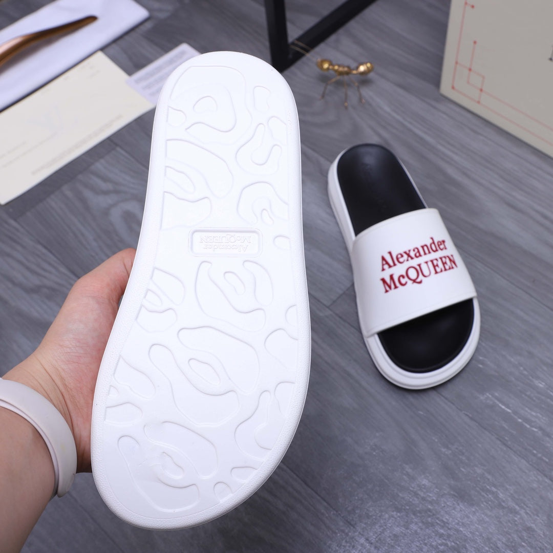 White slide sandal outsole with molded pattern; other shows red Alexander McQueen logo.