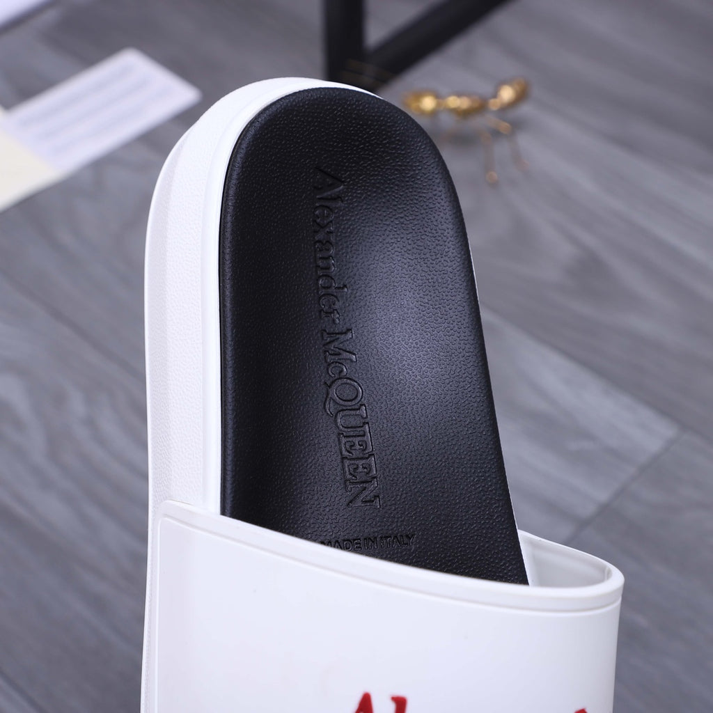 Black footbed with embossed Alexander McQueen text inside a white slide sandal.