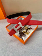 Red leather Hermes belt with silver-tone H buckle shown in an orange gift box