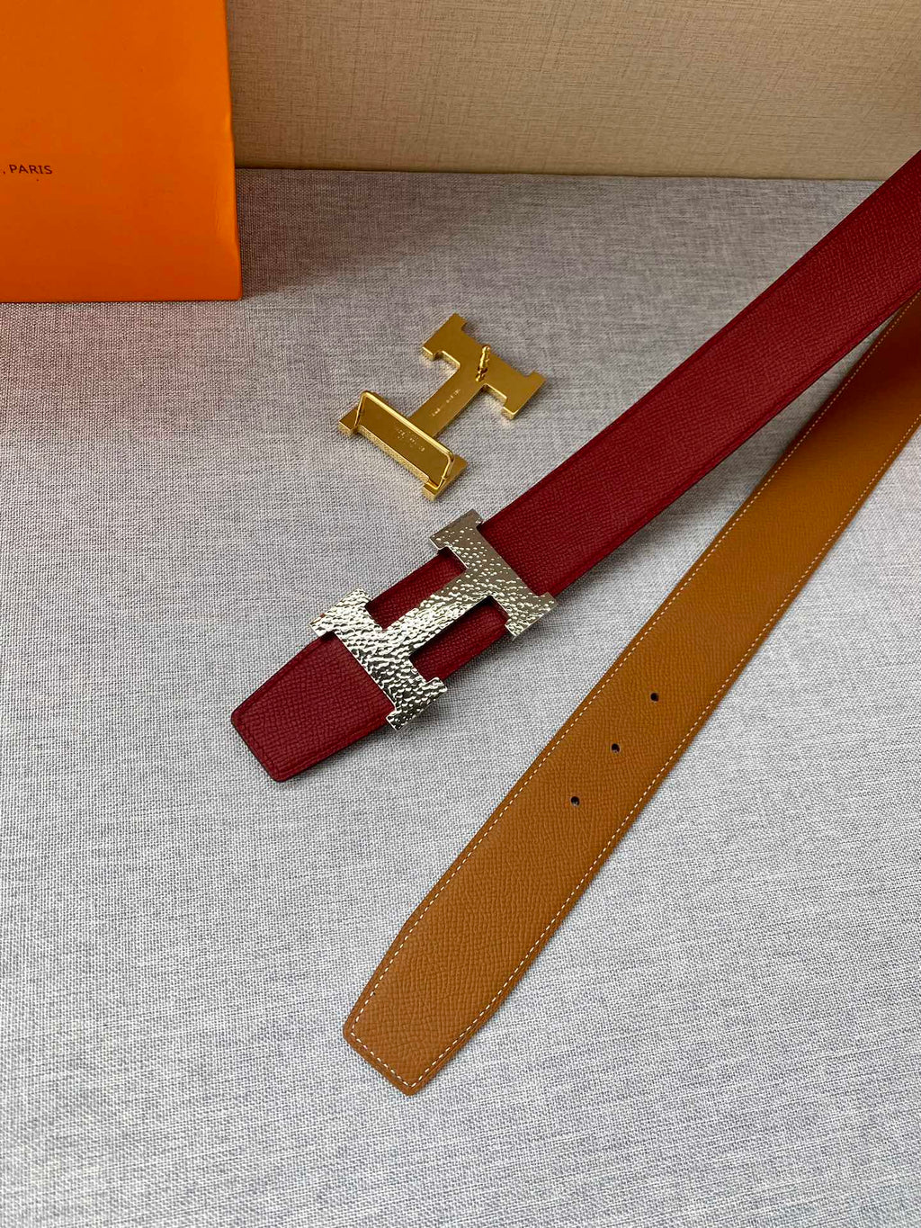Red and tan leather belt with gold-tone H buckle and keeper tab
