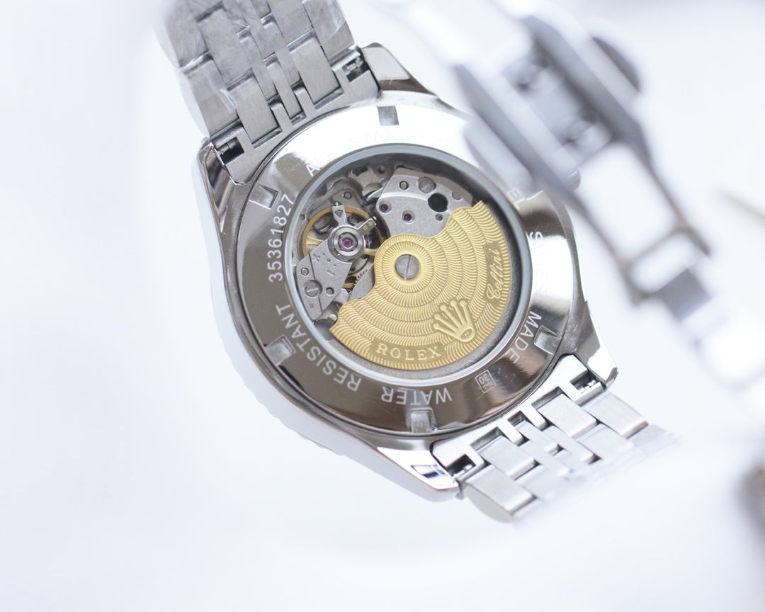 Rolex watch open caseback view with visible movement, silver metal bracelet