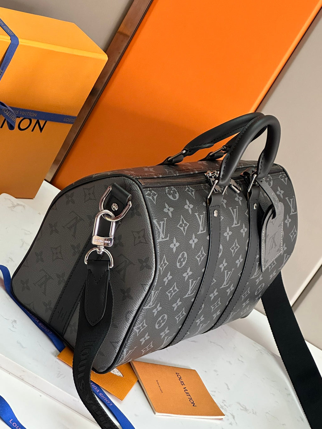 Louis Vuitton monogram duffel with black top handles and crossbody strap