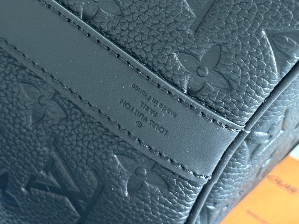 Men's Louis Vuitton leather bag with stitched panel and embossed monogram texture