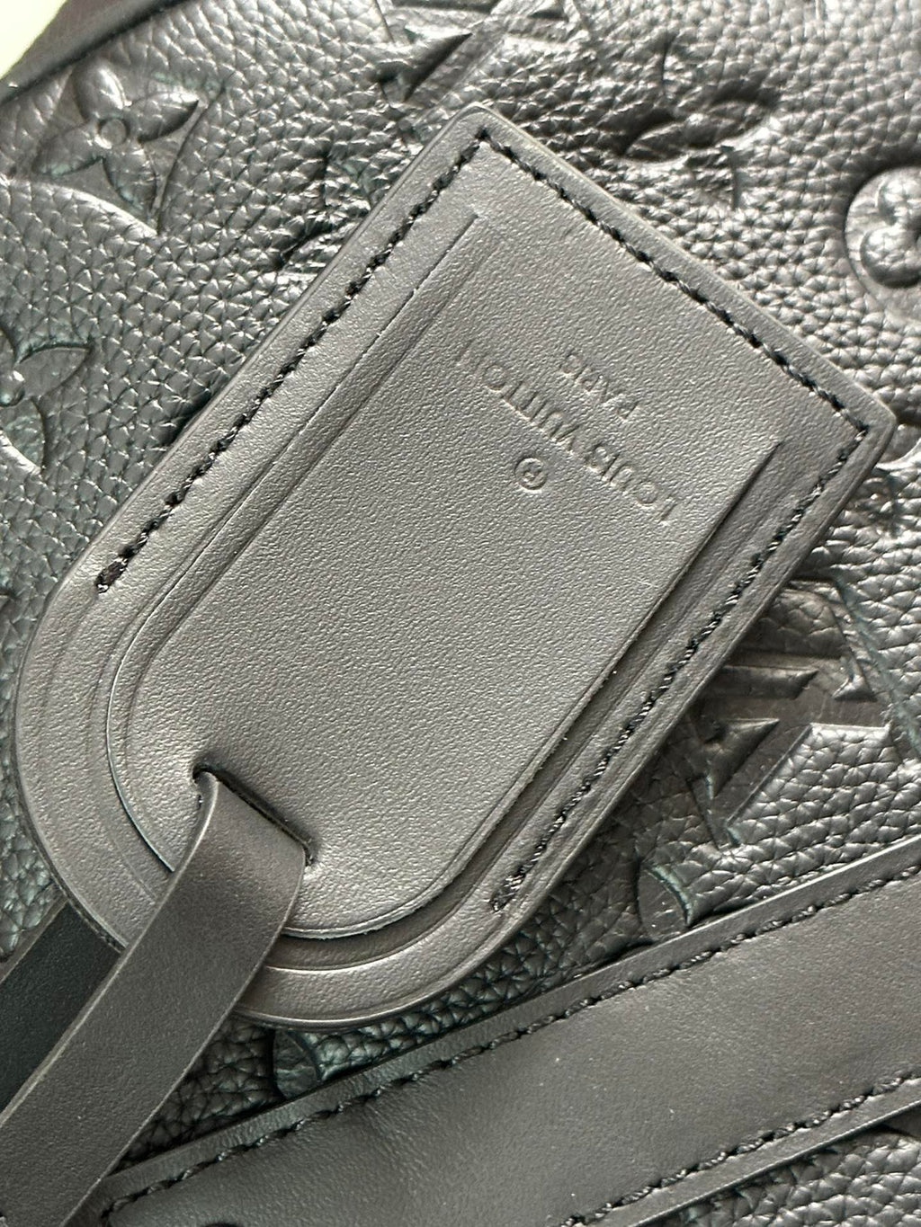 Men's Louis Vuitton leather luggage tag detail on monogram bag