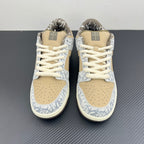 Nike Dunk SB low-top sneakers with beige laces, blue-and-white patterned toe and tan panels