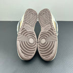 Nike Dunk SB sneakers with light gray treaded outsoles, beige and patterned upper