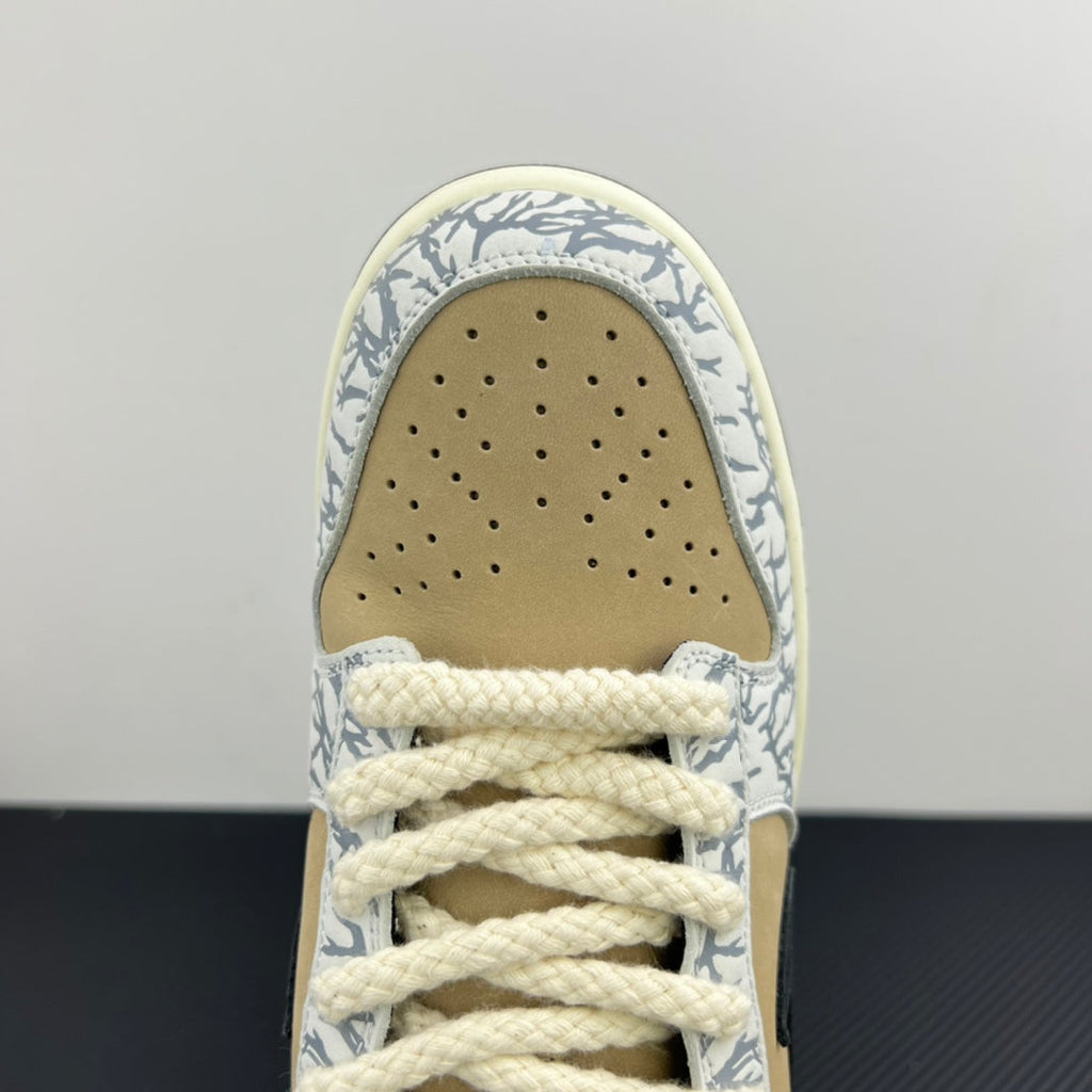 Nike Dunk SB toe box close-up with perforations, beige suede, and blue-white patterned trim