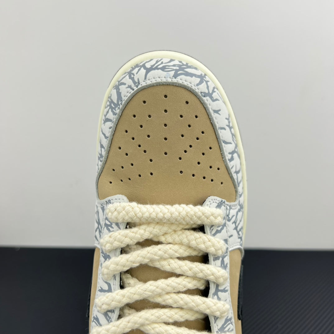 Nike Dunk SB toe box close-up with perforations, beige suede, and blue-white patterned trim