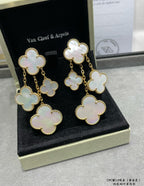 Gold-tone clover dangle earrings with iridescent mother-of-pearl motifs in gift box