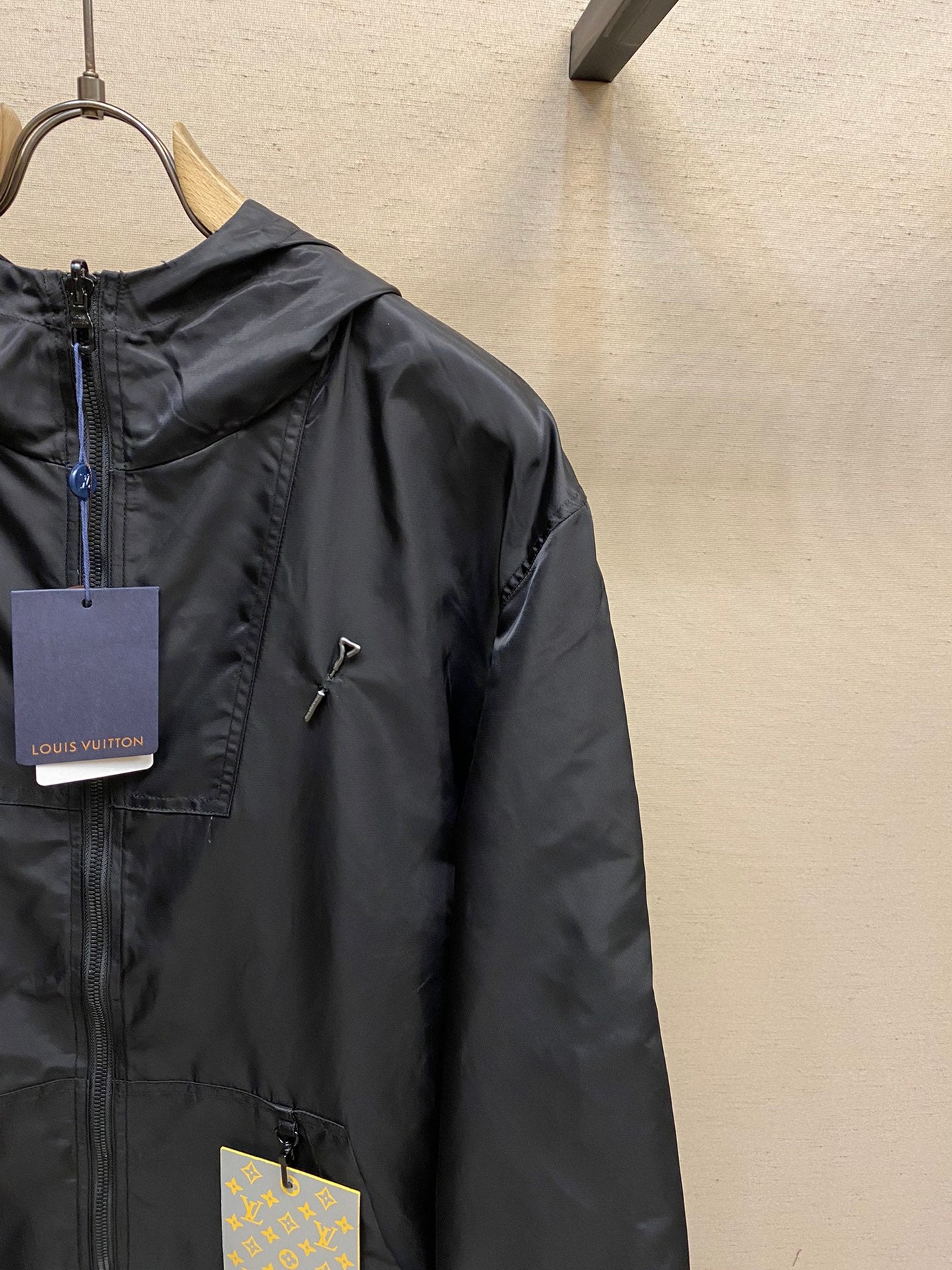 Black hooded jacket detail, full-zip front and hood with logo hardware