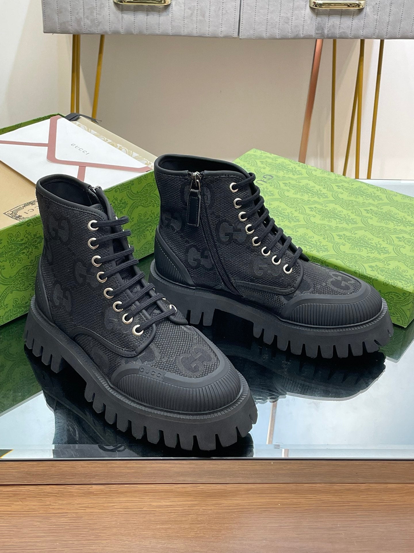 Gucci high-top lace-up sneakers with dark monogram pattern and chunky lug sole