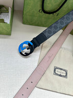 Designer belt with monogram strap and blue interlocking buckle, with light pink underside