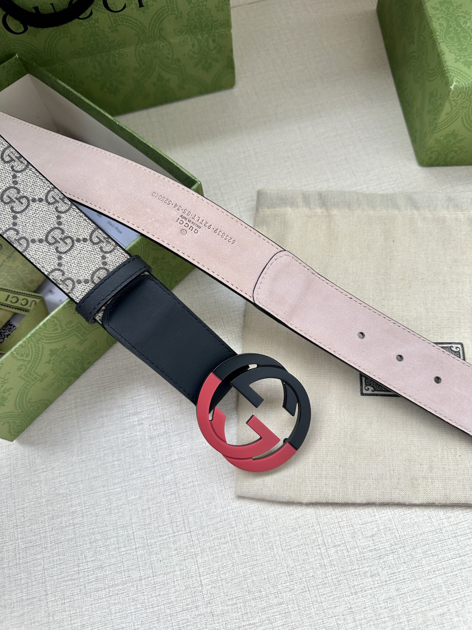 Gucci belt with pale pink lining, navy strap, and red-black circular G buckle