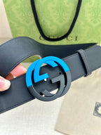 Dark blue leather belt with close-up of round GG buckle and blue outer ring