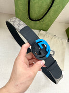 Designer belt with dark blue leather strap and round blue-accent GG buckle