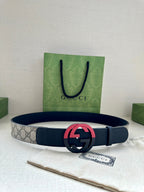 Dark blue leather belt with gray canvas center and pink/red GG buckle