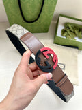 Brown leather belt with round black buckle and dark strap underside, shown in hand