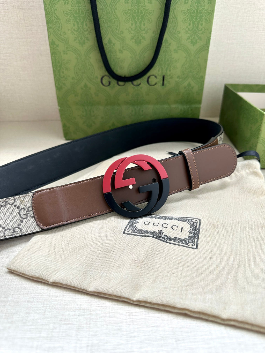 Brown leather belt with round black buckle, wide strap with stitching detail