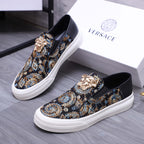 Versace slip-on sneaker with dark upper, gold and blue ornate pattern, and white rubber sole