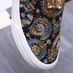 Versace slip-on sneaker detail, dark upper with intricate gold and blue medallion embroidery