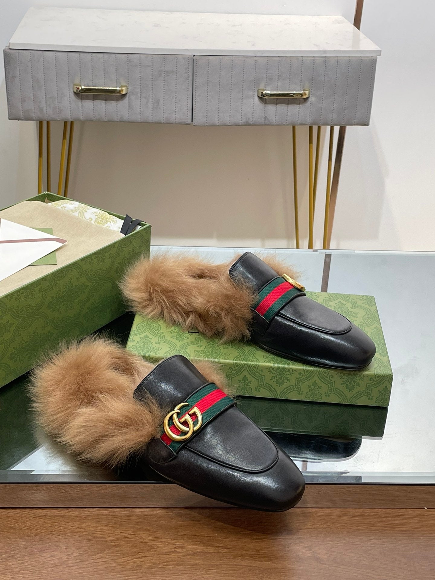 Gucci black fur slides with green-red web strap and gold GG buckle, pair on box