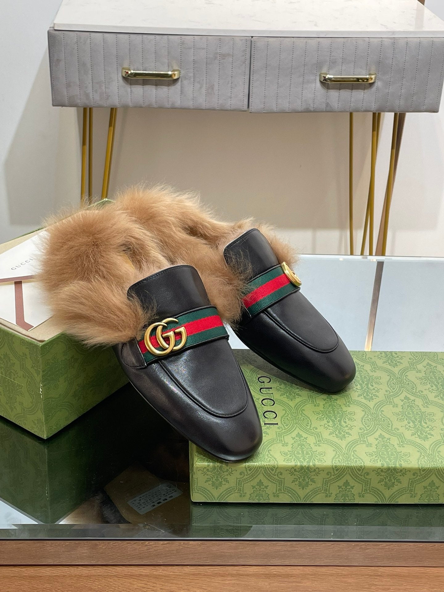 Gucci black fur slides with green-red web strap, gold GG emblem, rounded toe