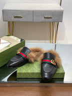 Gucci black fur slides with green-red web strap and gold GG buckle, side view