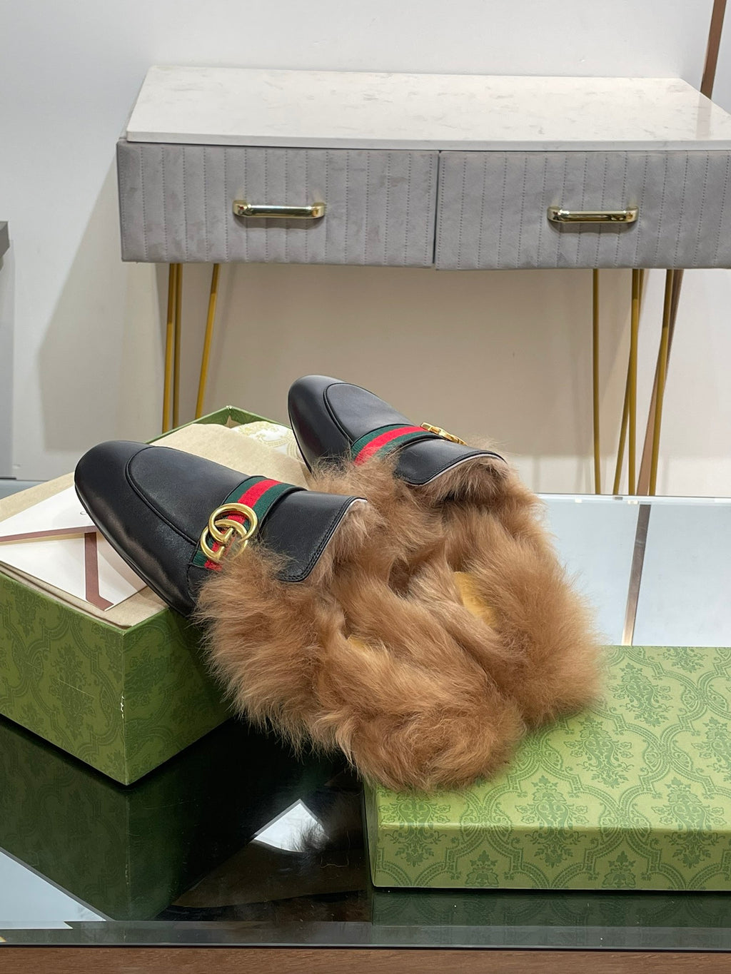 Gucci black fur slide sandals with green-red web strap and gold GG buckle hardware