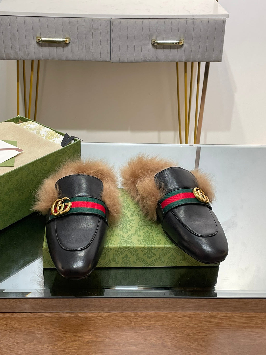 Gucci black fur slides with green-red web strap and gold GG buckle details