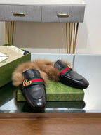 Gucci black fur slide sandals with green-red stripe strap and gold GG buckle