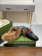 Gucci black fur slide sandals with gold GG strap detail and green-red accent