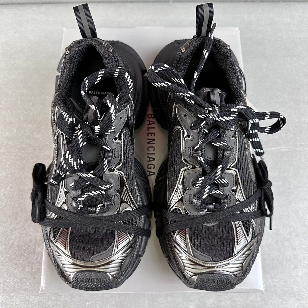 Pair of black and silver Balenciaga sneakers showing tongue and lace-up front