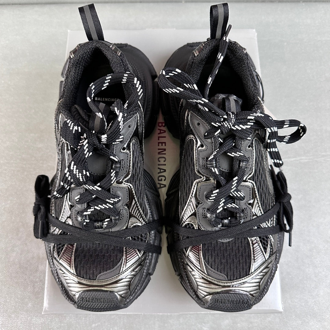 Pair of black and silver Balenciaga sneakers showing tongue and lace-up front